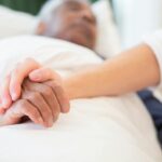 young persons hand holding an old persons hand